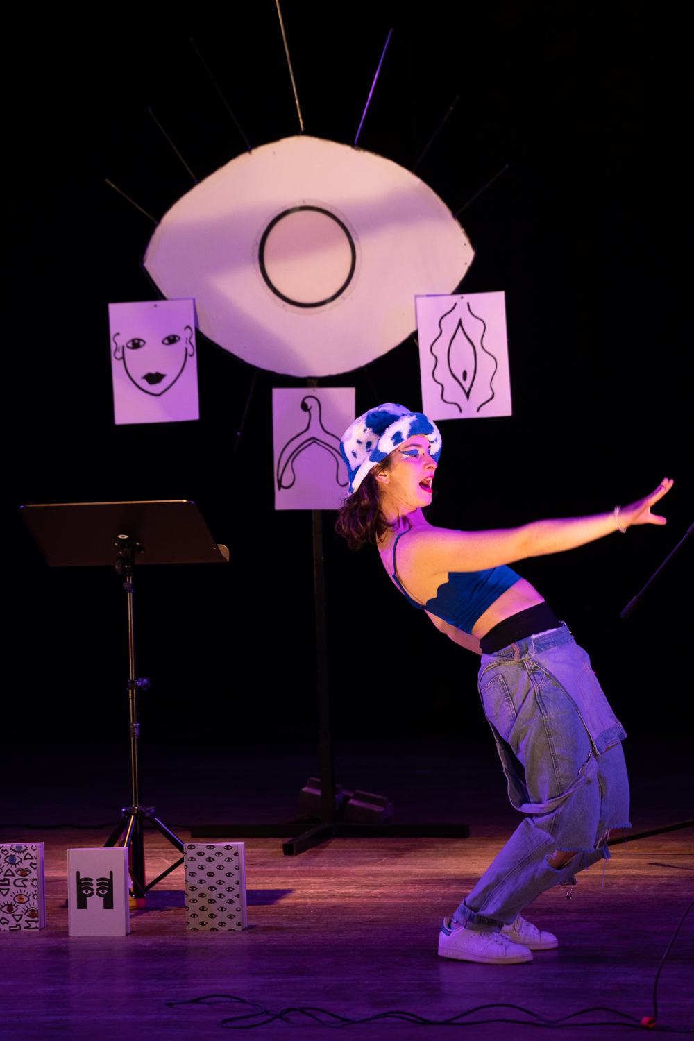 Spectacle In Limbo Yahnn Owen une femme au premier plan danse avec un oeil et des dessins en papier en fond